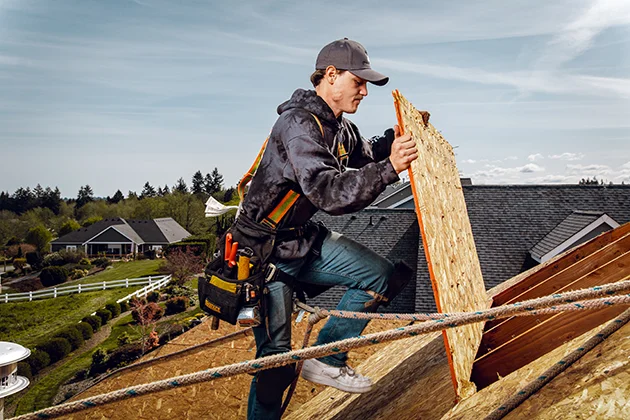 Roofing professional applying decking to a new roof