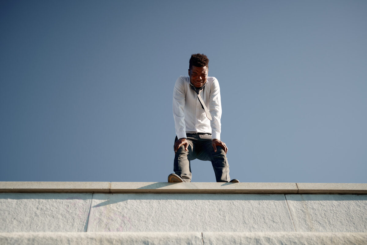 homeowner on top of roof looking defeated after attempting diy roof project