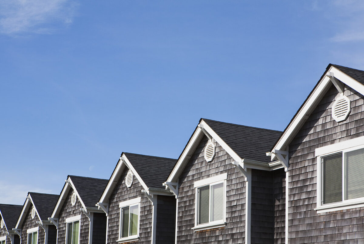 row of houses in suburban neighborhood illustrating a pitched roof